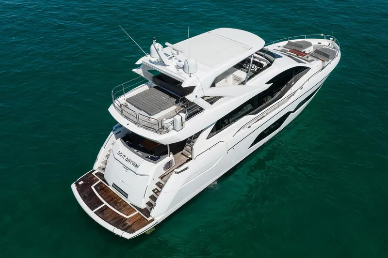 Do It Anyway Yacht Photos Pics 2018 Sunseeker 76 Yacht cruising on clear blue water, aerial view.