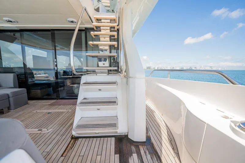 Do It Anyway Yacht Photos Pics Luxurious 2018 Sunseeker 76 Yacht deck with stairs, ocean view, and modern interior.