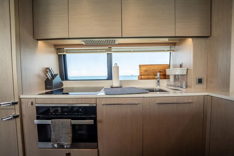 Do It Anyway Yacht Photos Pics Modern kitchen interior on 2018 Sunseeker 76 Yacht with ocean view window.