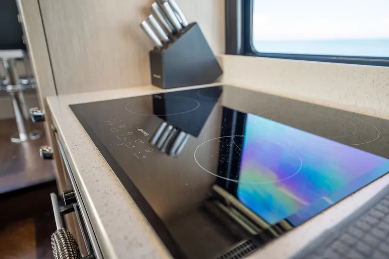 Do It Anyway Yacht Photos Pics Modern kitchen on 2018 Sunseeker 76 Yacht with sleek induction cooktop and knife set.