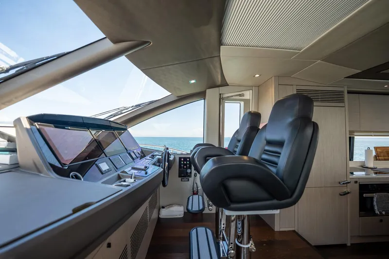 Do It Anyway Yacht Photos Pics Interior helm of 2018 Sunseeker 76 Yacht with leather seats and ocean view.