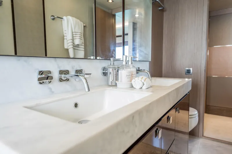 Do It Anyway Yacht Photos Pics Luxurious bathroom in 2018 Sunseeker 76 Yacht with marble countertop and modern fixtures.