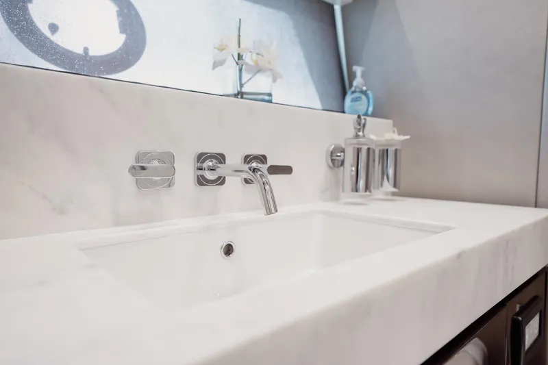 Do It Anyway Yacht Photos Pics Luxurious bathroom sink on 2018 Sunseeker 76 Yacht with marble countertop and modern fixtures.