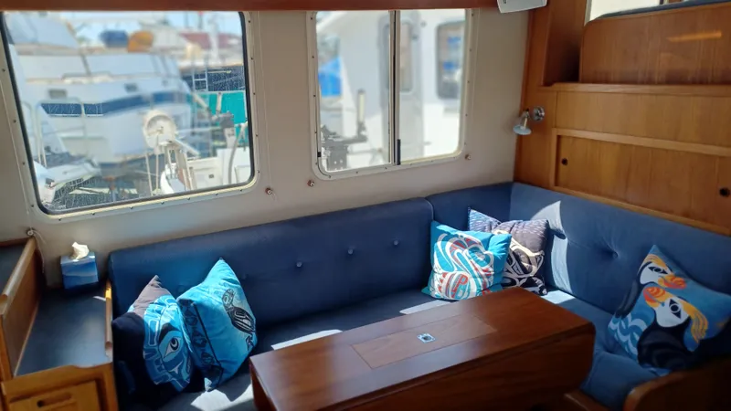 Rafiki Yacht Photos Pics Cozy interior of 2000 Nordic Tug 37 with blue seating and decorative pillows.