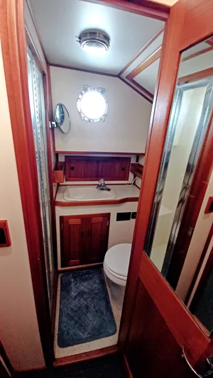 Rafiki Yacht Photos Pics Bathroom interior of 2000 Nordic Tug 37 with wooden cabinetry and nautical decor.