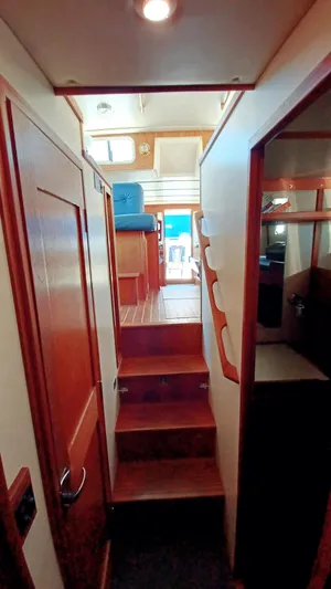 Rafiki Yacht Photos Pics Interior view of 2000 Nordic Tug 37, featuring wooden stairs and cozy cabin layout.