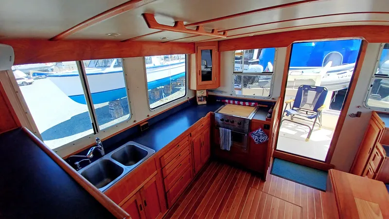 Rafiki Yacht Photos Pics Interior of 2000 Nordic Tug 37, featuring a spacious kitchen with wooden cabinetry and dual sinks.