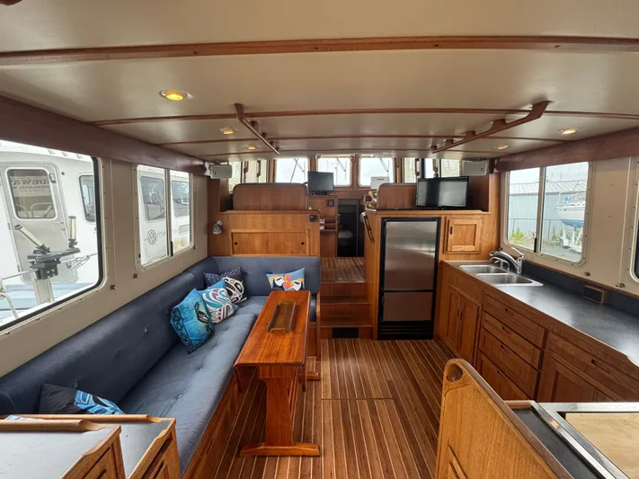 Rafiki Yacht Photos Pics Interior of 2000 Nordic Tug 37, featuring wood finishes, seating, and kitchenette.