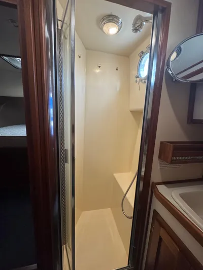 Rafiki Yacht Photos Pics Shower area in a 2000 Nordic Tug 37 boat, featuring a compact design with a porthole.