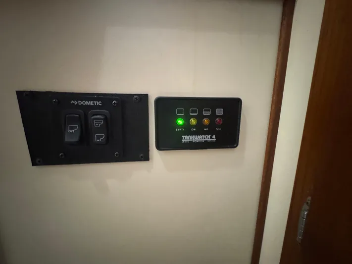 Rafiki Yacht Photos Pics Control panel on a 2000 Nordic Tug 37 boat, featuring Dometic switches and TankWatch 4 indicators.