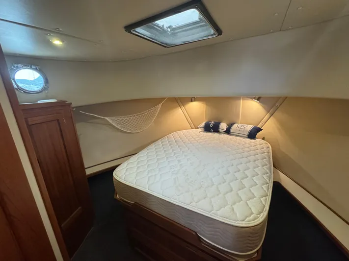 Rafiki Yacht Photos Pics Cozy cabin interior of 2000 Nordic Tug 37 with bed and porthole.