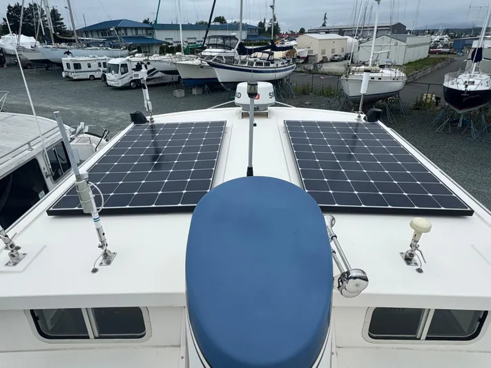 Rafiki Yacht Photos Pics Nordic Tug 37 (2000) with solar panels on deck, docked in a marina.