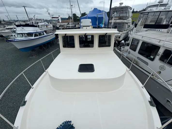 Rafiki Yacht Photos Pics Nordic Tug 37, 2000 model, docked among other boats in a marina.