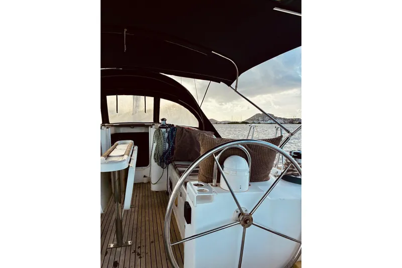 Further Yacht Photos Pics Cockpit view of 2005 Beneteau Oceanis 473 sailboat with scenic water backdrop.