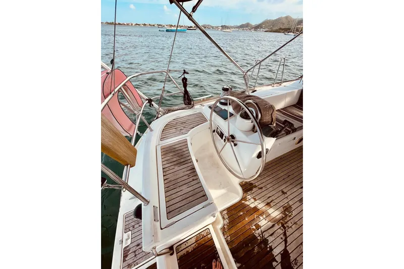 Further Yacht Photos Pics Cockpit of 2005 Beneteau Oceanis 473 sailboat with wooden deck and steering wheel.