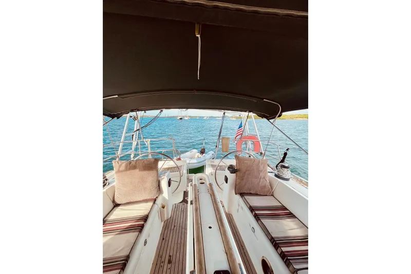 Further Yacht Photos Pics 2005 Beneteau Oceanis 473 sailboat interior with cushions, ocean view, and American flag.