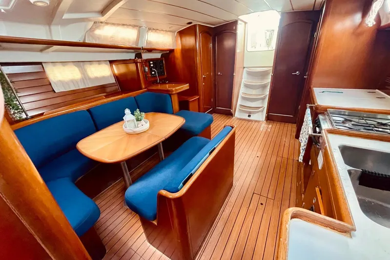 Further Yacht Photos Pics Interior of 2005 Beneteau Oceanis 473 yacht with wooden flooring and blue seating.