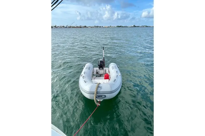 Further Yacht Photos Pics Inflatable dinghy tethered to a 2005 Beneteau Oceanis 473 sailboat on calm waters.