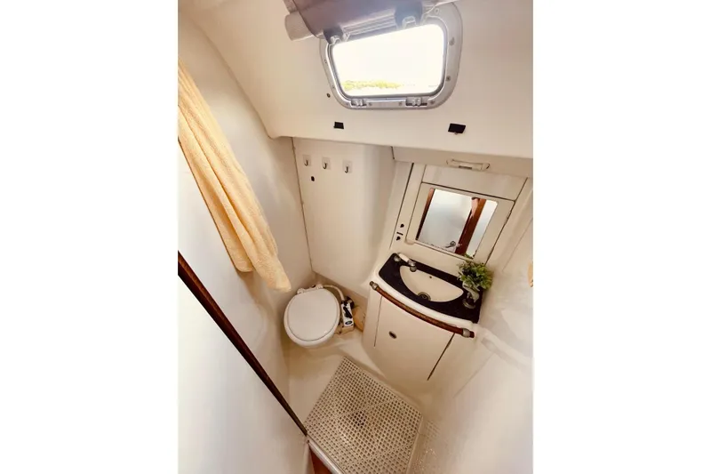 Further Yacht Photos Pics Compact bathroom in 2005 Beneteau Oceanis 473 yacht with sink, toilet, and window.