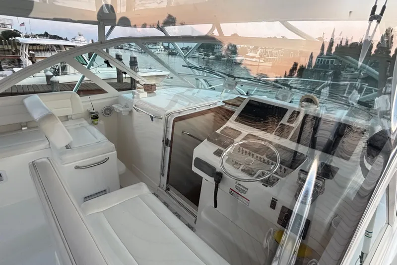  Yacht Photos Pics 2010 Cabo 36 Express boat interior with helm, white seating, and marina view.