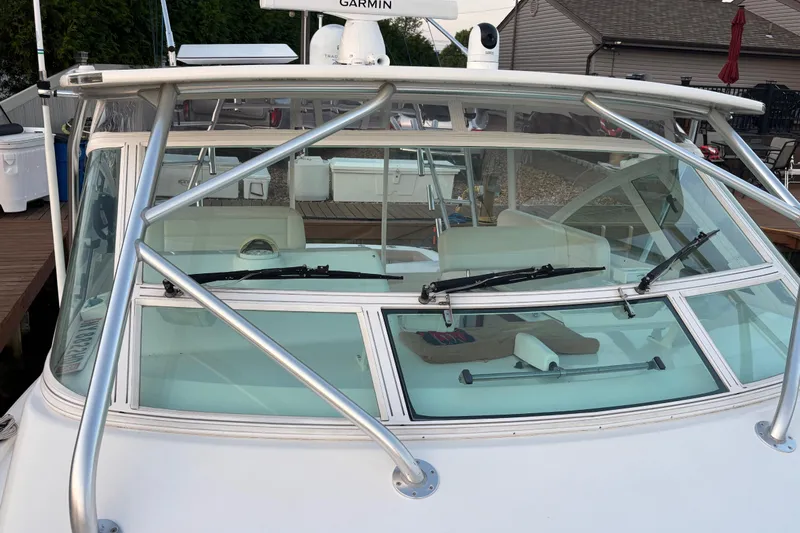  Yacht Photos Pics 2010 Cabo 36 Express boat with windshield and wipers, docked near a wooden pier.