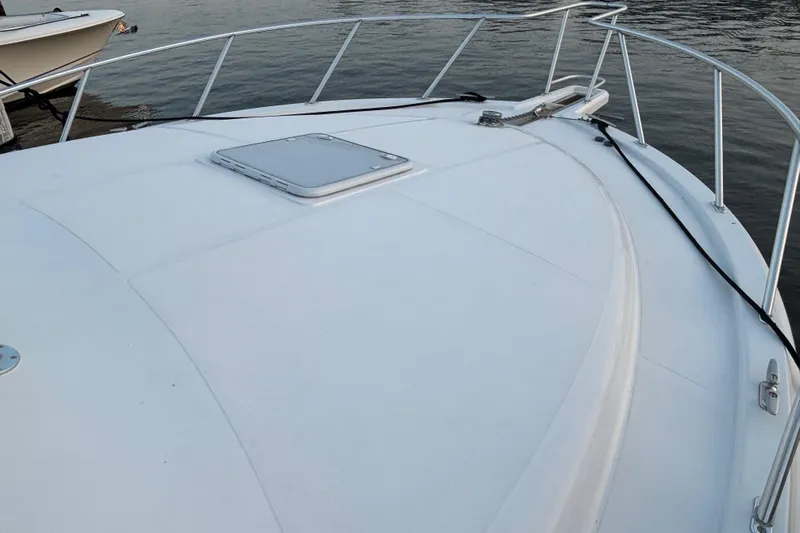  Yacht Photos Pics 2010 Cabo 36 Express boat deck with railing, docked on calm water.