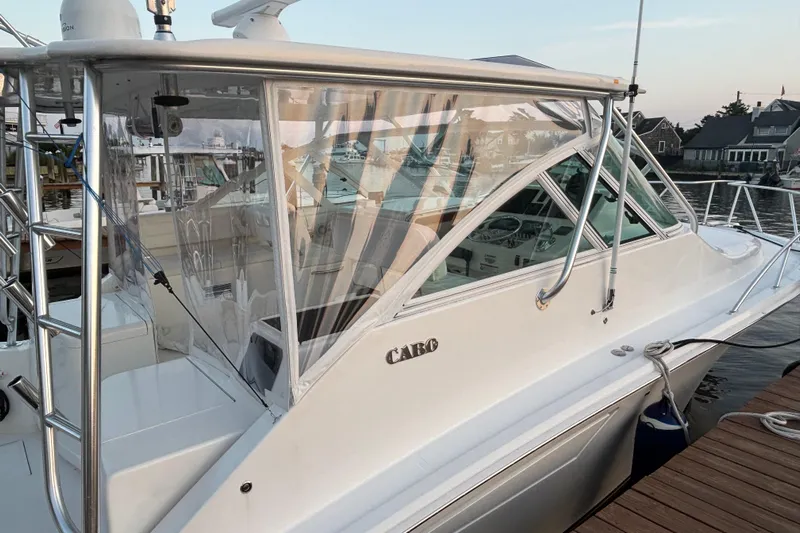  Yacht Photos Pics 2010 Cabo 36 Express boat docked, featuring sleek design and clear enclosure.