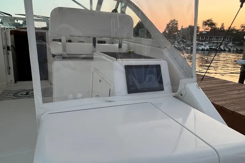  Yacht Photos Pics 2010 Cabo 36 Express boat interior with helm, docked at sunset.