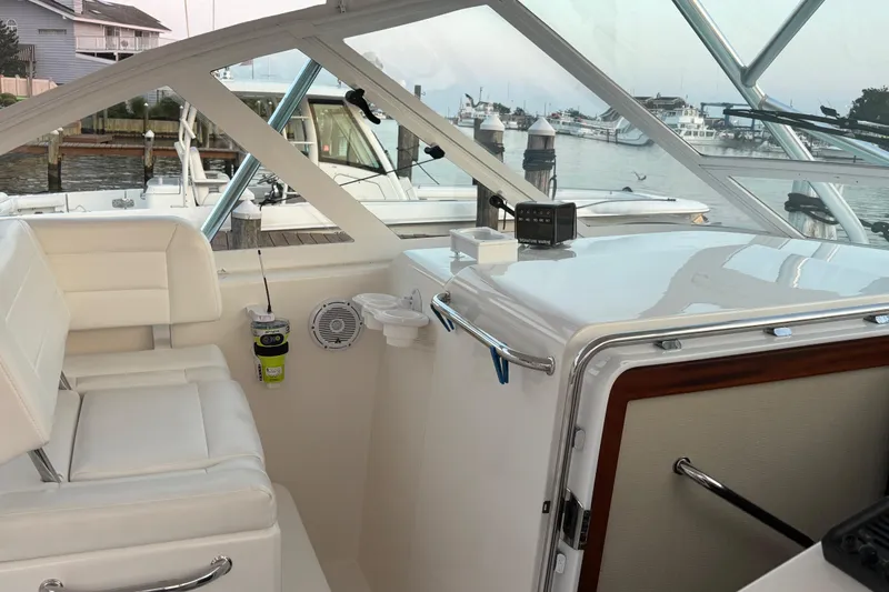  Yacht Photos Pics Interior of a 2010 Cabo 36 Express boat with white seating and marina view.