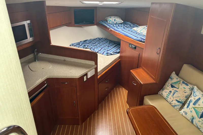  Yacht Photos Pics 2010 Cabo 36 Express cabin interior with kitchenette, bunk beds, and seating area.