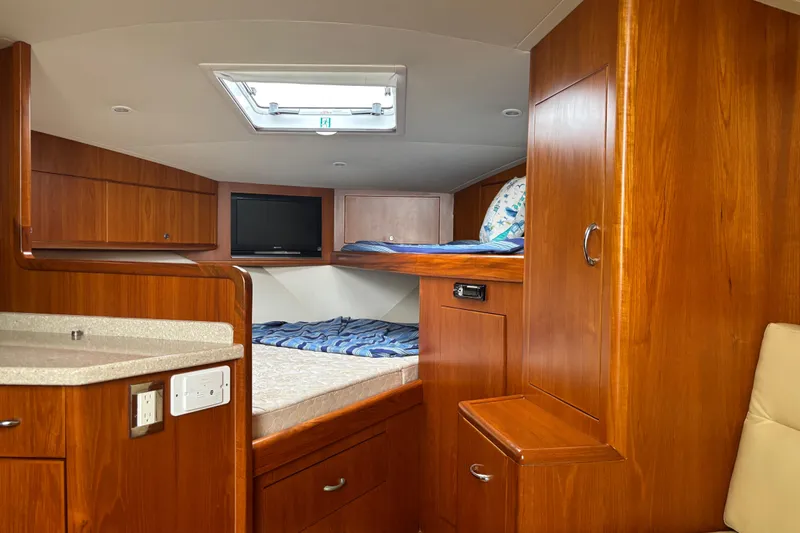  Yacht Photos Pics Luxurious 2010 Cabo 36 Express yacht interior with wood cabinetry and cozy sleeping area.