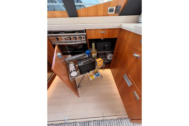 Cross Wind Yacht Photos Pics Modern kitchen interior of 2016 Moody Decksaloon 54 yacht with open storage cabinet.