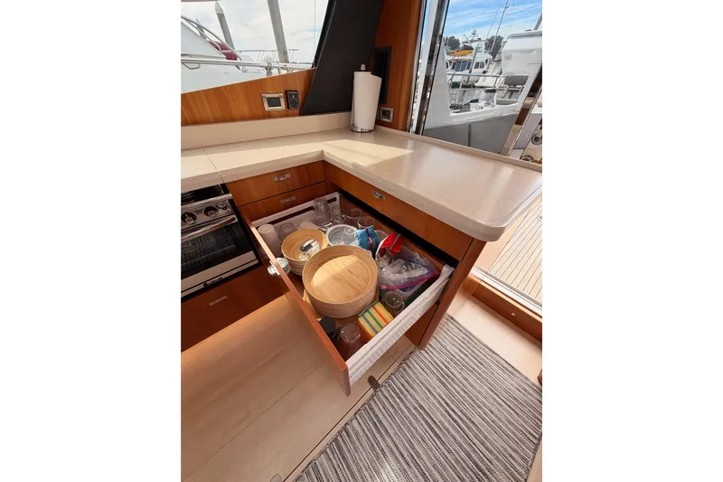 Cross Wind Yacht Photos Pics Modern kitchen interior of 2016 Moody Decksaloon 54 yacht with open drawer and countertop.