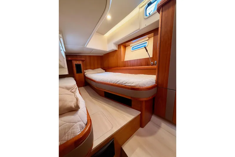 Cross Wind Yacht Photos Pics Luxurious cabin interior of 2016 Moody Decksaloon 54 yacht with wooden finishes and cozy beds.