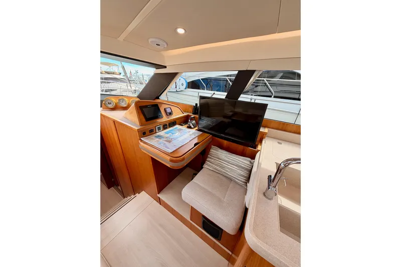 Cross Wind Yacht Photos Pics Luxurious interior of 2016 Moody Decksaloon 54 yacht with navigation station and seating area.