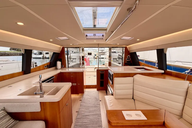 Cross Wind Yacht Photos Pics Luxurious interior of 2016 Moody Decksaloon 54 yacht with modern kitchen and seating area.