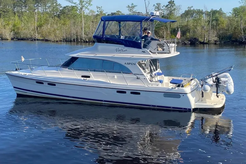 Vita Nova Yacht Photos Pics 2018 Aspen C120 yacht cruising on a calm river with lush greenery in the background.