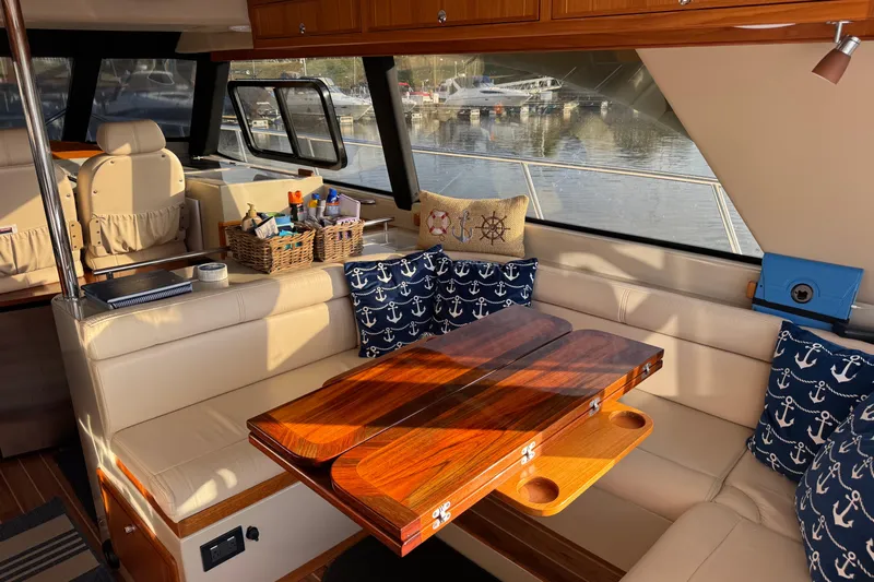Vita Nova Yacht Photos Pics Luxurious interior of 2018 Aspen C120 boat with nautical-themed decor and wooden table.