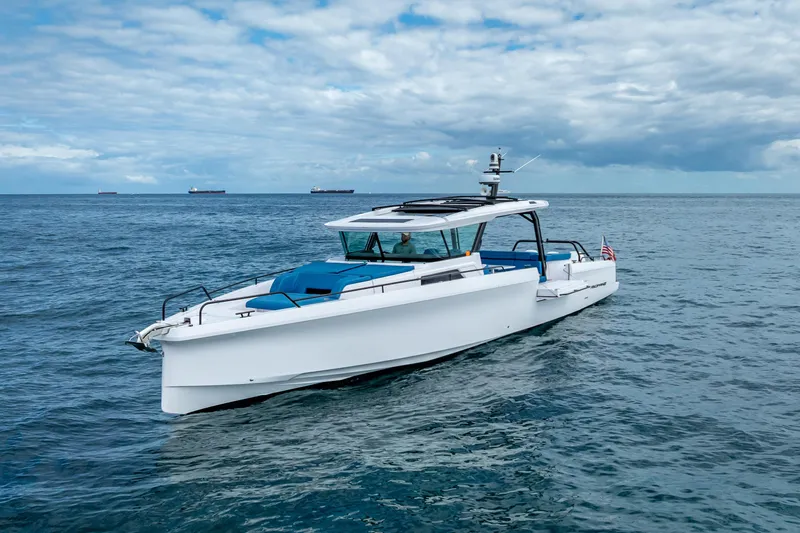  Yacht Photos Pics 2025 Axopar 45 Cross Top boat cruising on open water under a cloudy sky.