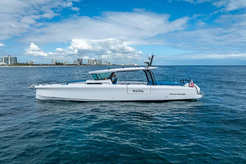  Yacht Photos Pics 2025 Axopar 45 Cross Top boat cruising on open water under a blue sky.