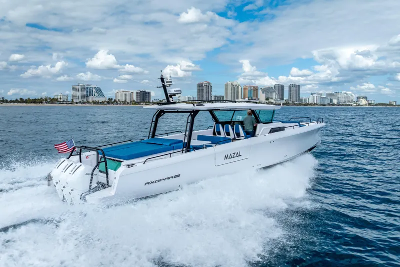  Yacht Photos Pics 2025 Axopar 45 Cross Top cruising near city skyline on a sunny day.
