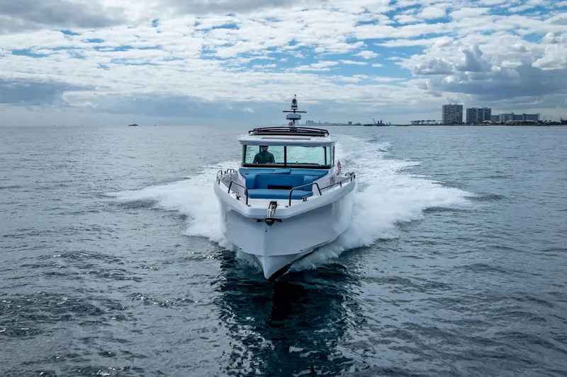  Yacht Photos Pics 2025 Axopar 45 Cross Top cruising on open water under a cloudy sky.