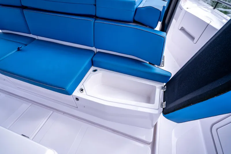  Yacht Photos Pics 2025 Axopar 45 Cross Top boat with blue seating and storage compartment.