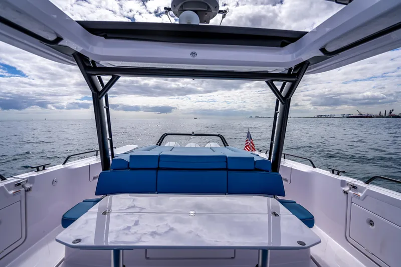  Yacht Photos Pics 2025 Axopar 45 Cross Top boat with blue seating, open sea view, and American flag.