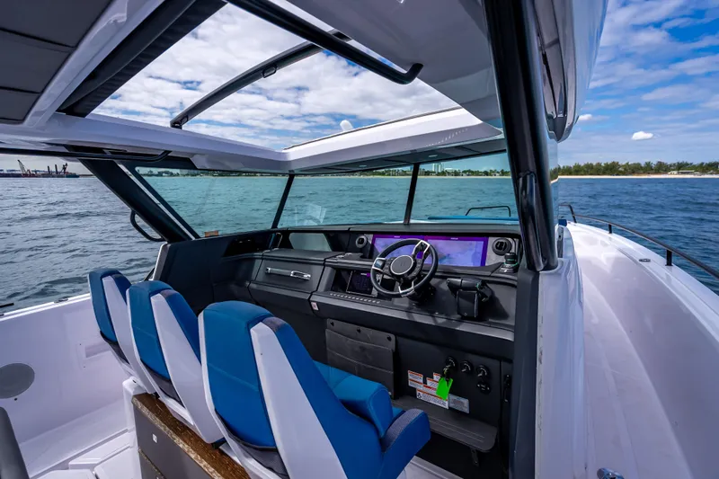  Yacht Photos Pics 2025 Axopar 45 Cross Top boat interior with blue seats and modern dashboard on open water.