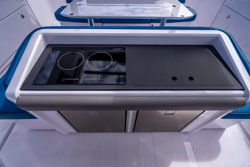  Yacht Photos Pics Modern kitchen area on 2025 Axopar 45 Cross Top boat, featuring sleek stovetop design.