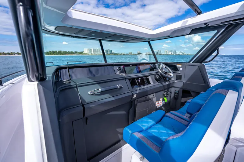  Yacht Photos Pics Interior view of 2025 Axopar 45 Cross Top boat with blue seating and modern dashboard.
