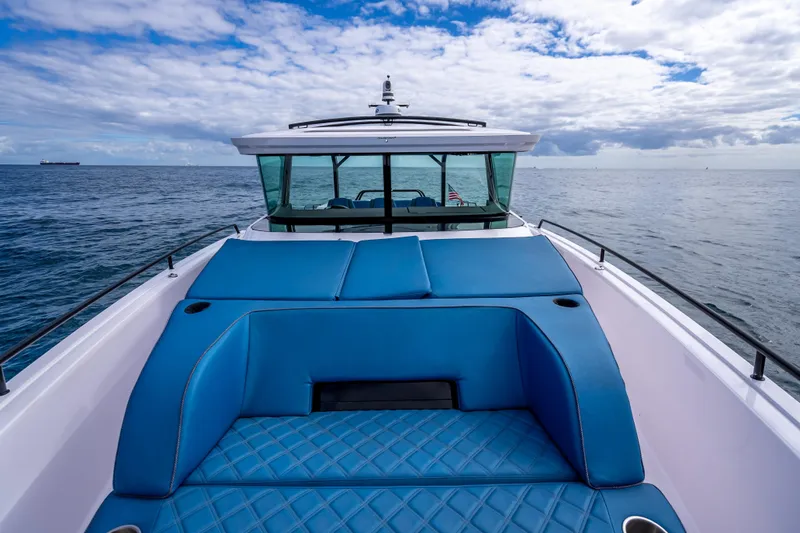  Yacht Photos Pics 2025 Axopar 45 Cross Top boat with blue seating, cruising on open water.