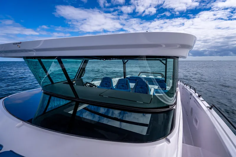  Yacht Photos Pics 2025 Axopar 45 Cross Top boat on open water under blue sky.