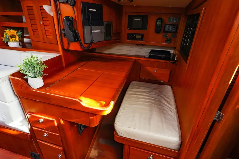 Mojo Yacht Photos Pics 2004 J Boats J/46 interior with navigation station, wood finish, and seating area.